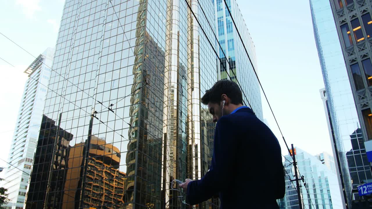 hombre de negocios escuchando música y usando teléfono móvil