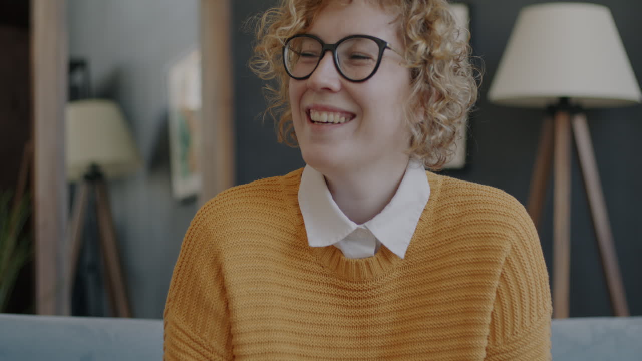 Donna che sorride e ride in un accogliente soggiorno