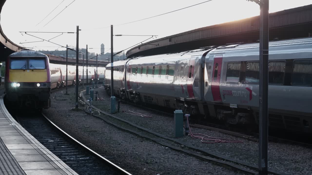 Treno passeggeri in arrivo e in transito in una stazione ferroviaria