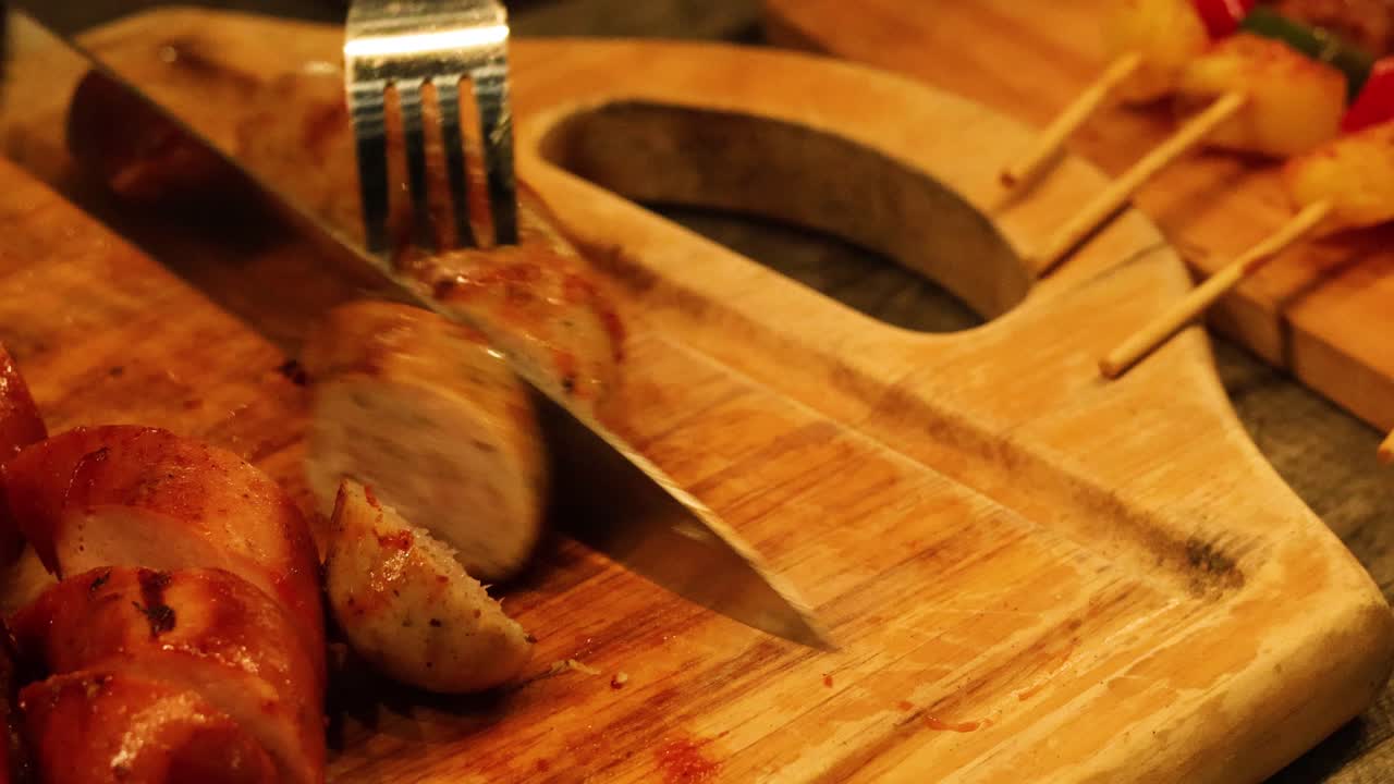 Tagliare la salsiccia a pezzi con coltello e forchetta