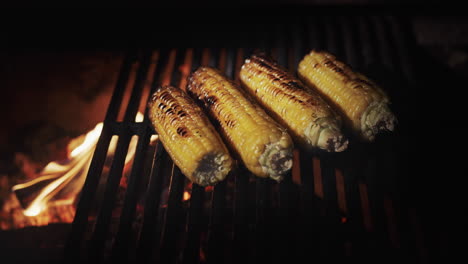 delicious cobs of corn are fried on the grill grill over hot coals