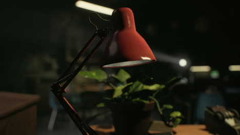 red desk lamp in a dark office