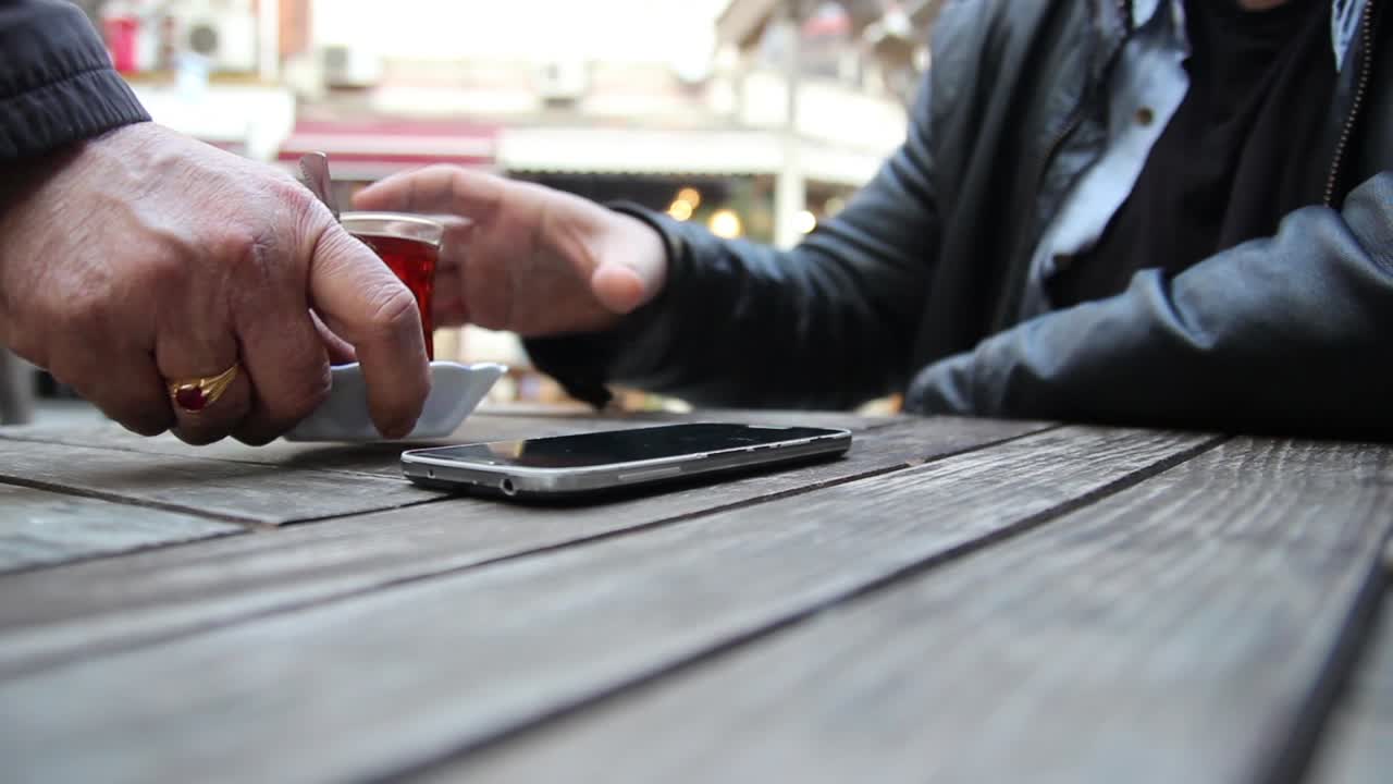 joven usando su teléfono inteligente en un café cerca de las manos 3