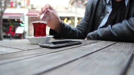 joven usando su teléfono inteligente en un café cerca de las manos 3