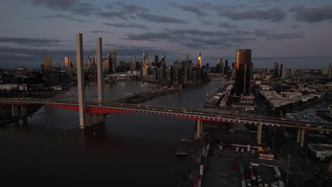 large twin cantilever road bridge over yarra river, melbourne skyline