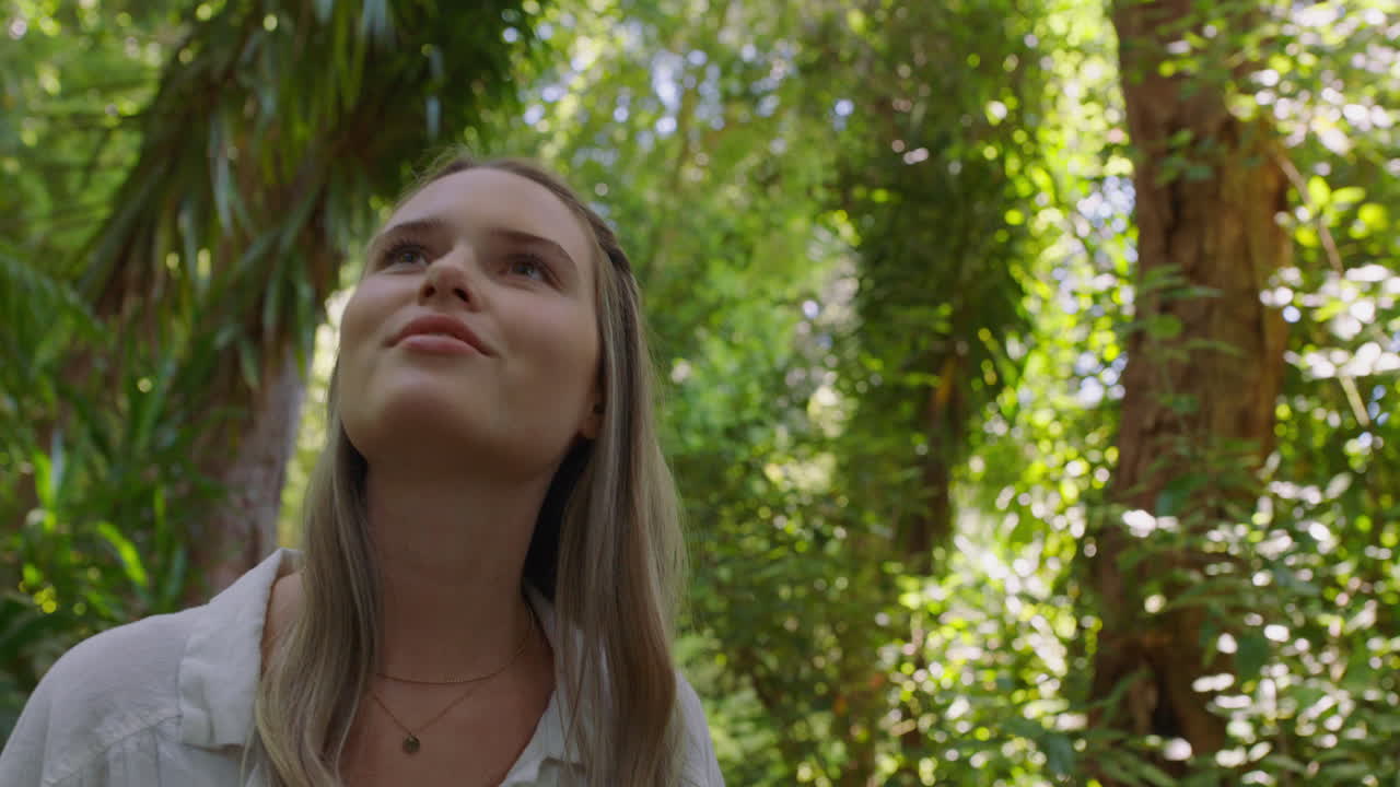 hermosa mujer caminando en el bosque naturaleza chica explorando exuberante jardín encantado por la belleza natural al aire libre 4k