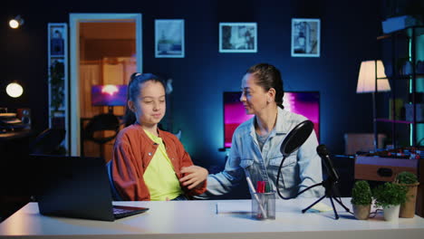 niña pequeña y su madre en la sala de estar utilizada como estudio profesional para grabar vlogs