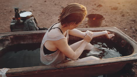 woman washing in dirty bath in post apocalyptic world