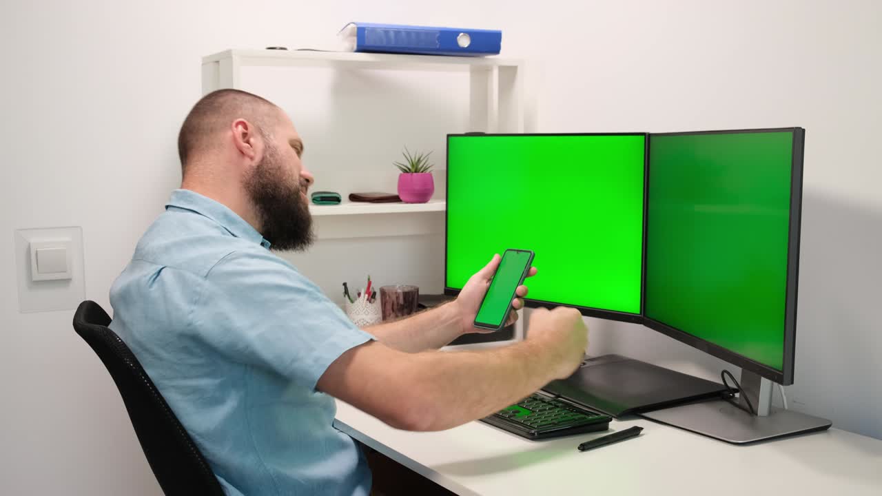 hombre de negocios que utiliza teléfonos móviles y computadoras con monitores de pantalla verde. trabajo en la oficina o en el hogar