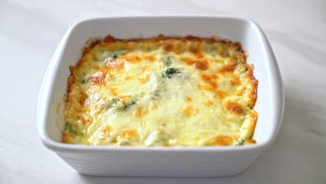 Lasaña de espinacas al horno con queso en placa blanca.