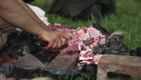 middle eastern man chops and cuts sheep meat to eat in celebration of muslim, religious holiday ramadan, eid al-adha or eid al-fitr in cinematic slow motion