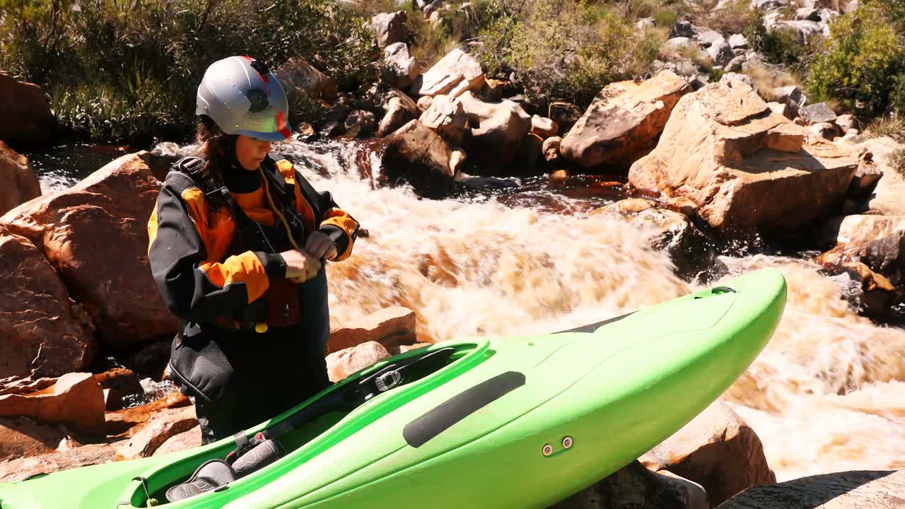 mujer preparándose para empezar a andar en kayak en el río 4k