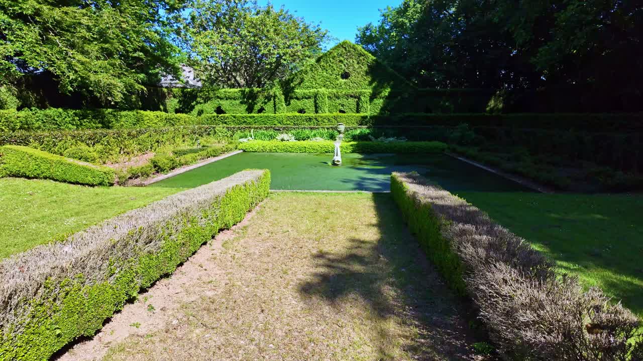 Stone-lined garden environment with vivid green surroundings at Upper Brittany Botanical Park, Le Chatellier, France.
