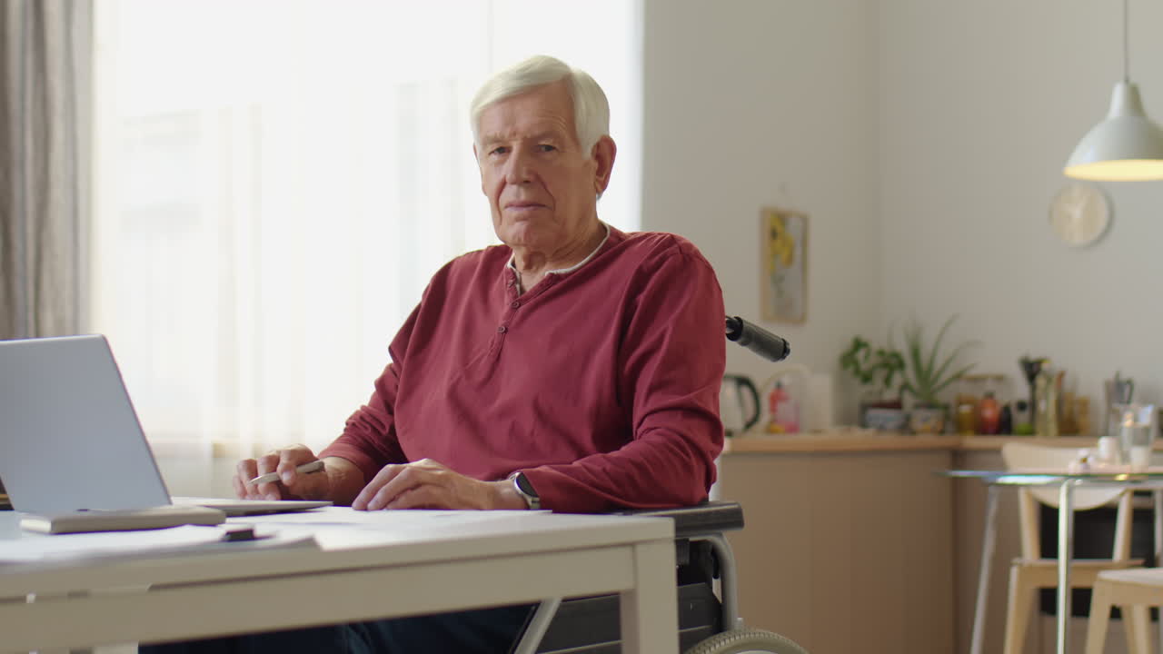 Senior Man in Wheelchair Posing for Camera at Home