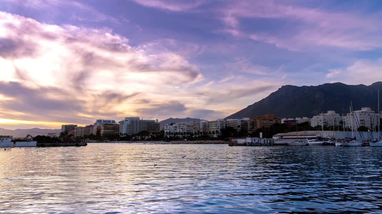 Marbella, time-lapse 4K di Marbella dal porto di pesca, splendida vista di nuvole in movimento al tramonto e barche a vela che si muovono nel porto