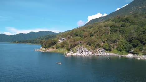 local fisherman paddling on a boat in lake atitlan, guatemala - aerial drone view