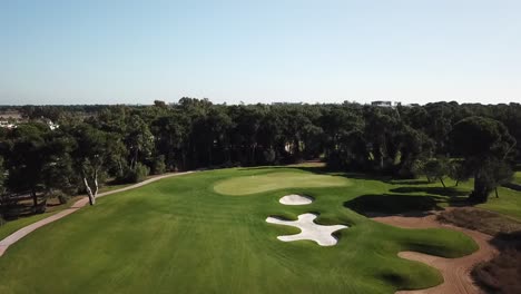 volando sobre un campo de golf verde y vívido y centrándose en el lugar del hoyo