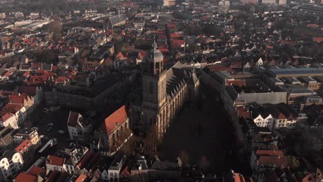 Aerial-rotating-movement-around-the-Lebuinuskerk-church-and-tower-in-the-central-square-of-the-Dutch-Hanseatic-medieval-city-Deventer-in-The-Netherlands