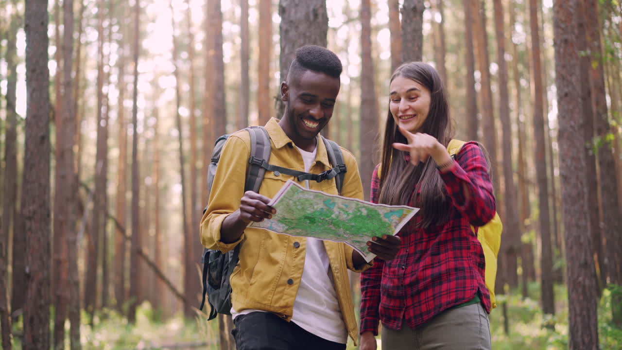 Couple Hiking in a Forest, Looking at a Map