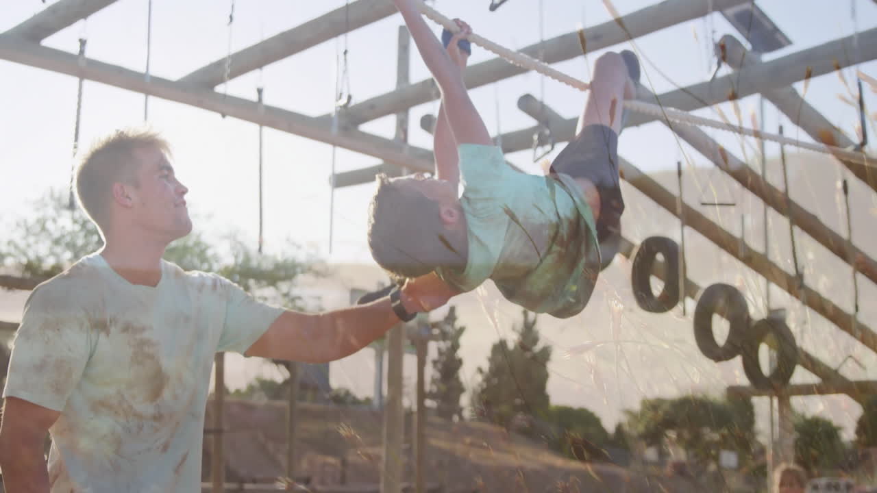 Climbing rope obstacle, child with adult support in outdoor adventure course