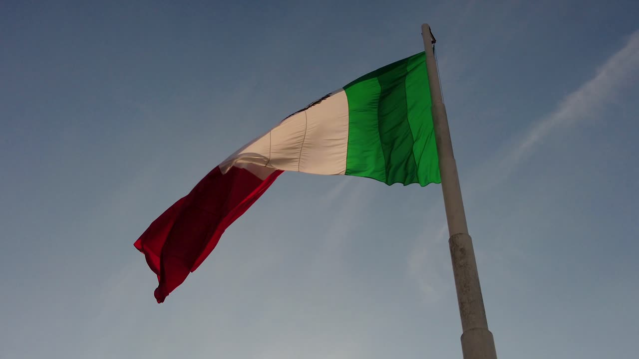 primo piano della bandiera messicana su un palo che sventola nel pomeriggio al tramonto all'alba del mattino