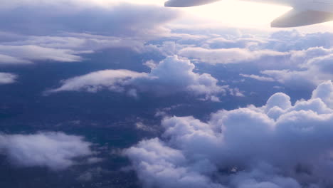 Taking-Off-in-an-Airplane-from-a-Window-With-Clouds-during-Travel-on-a-Flight-Wing