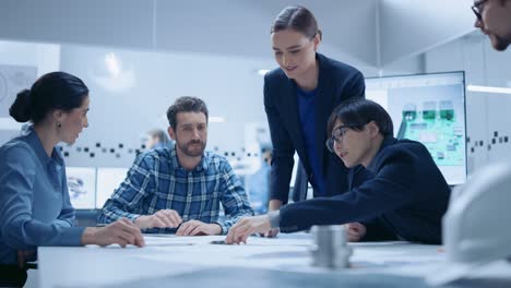 busy diverse team of computer engineers and specialists gather around conference table, they discuss project drafts and blueprints, find problem solutions. industrial technology office meeting room