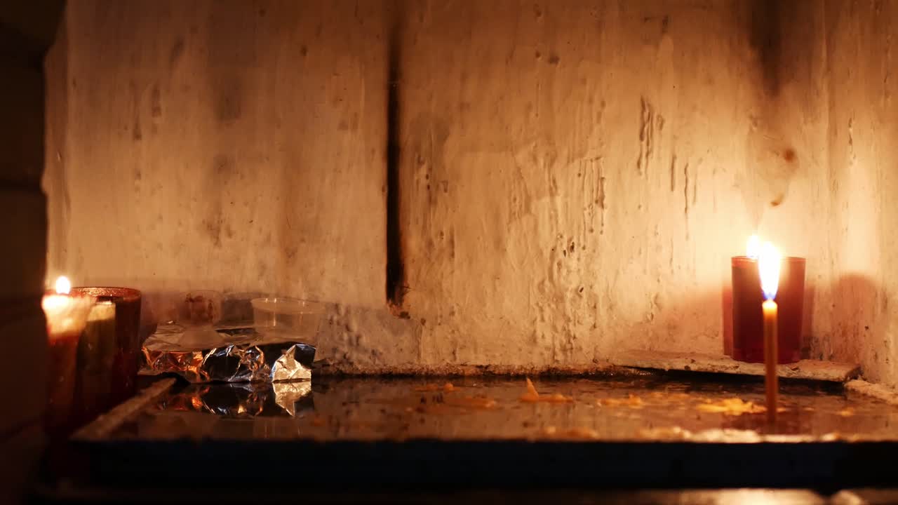 Locked shot of burning candles in a tiny hermitage