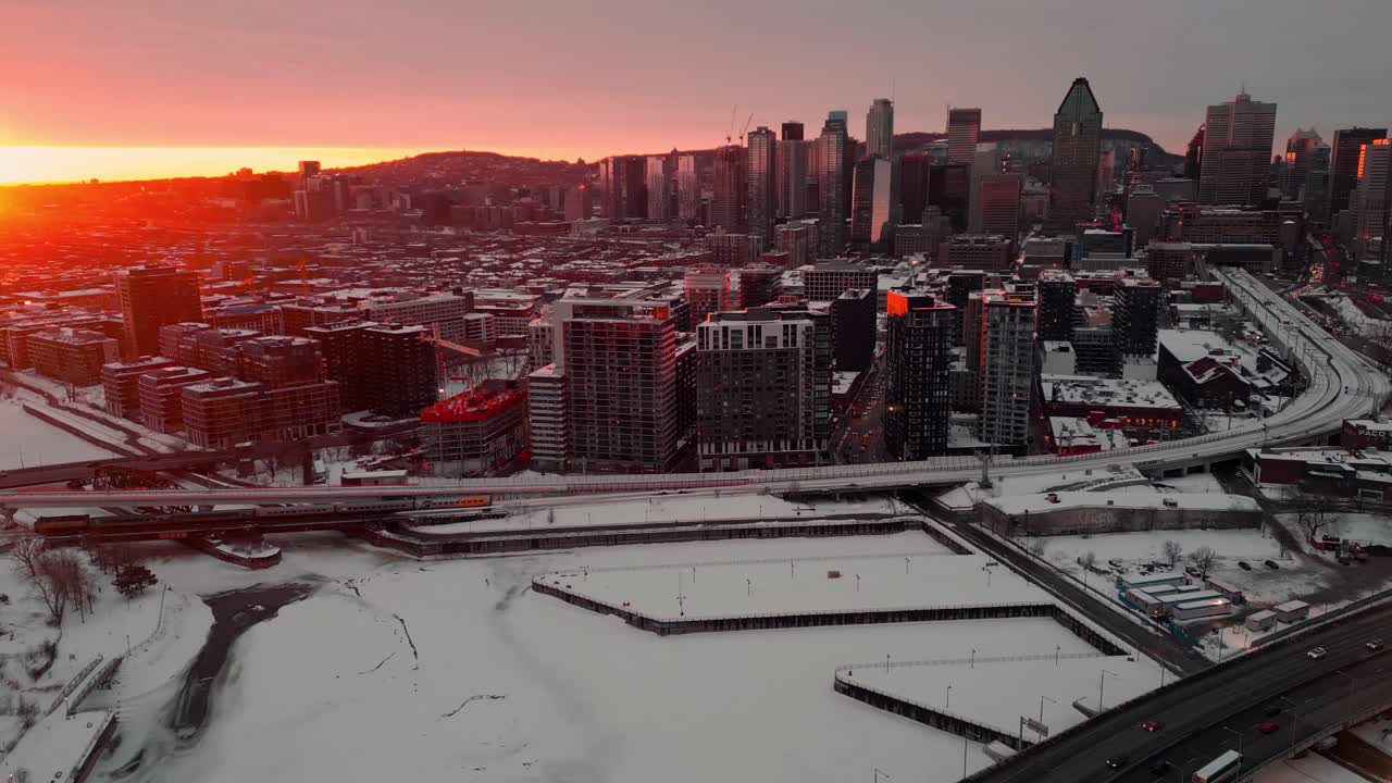 Ripresa aerea sulla città di Montreal al tramonto durante la stagione invernale che rivela lo skyline e il canale di Lachine, regione del Quebec, Canada