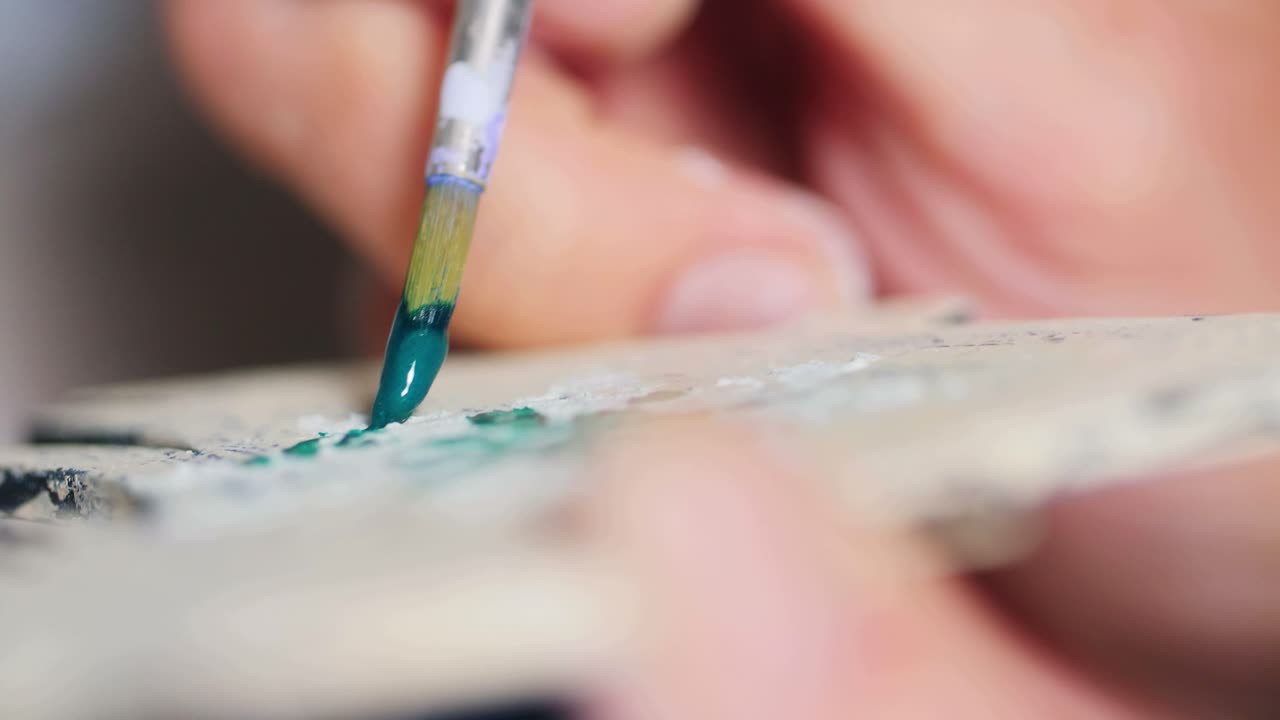 Closeup of an artist painting a ceramic piece