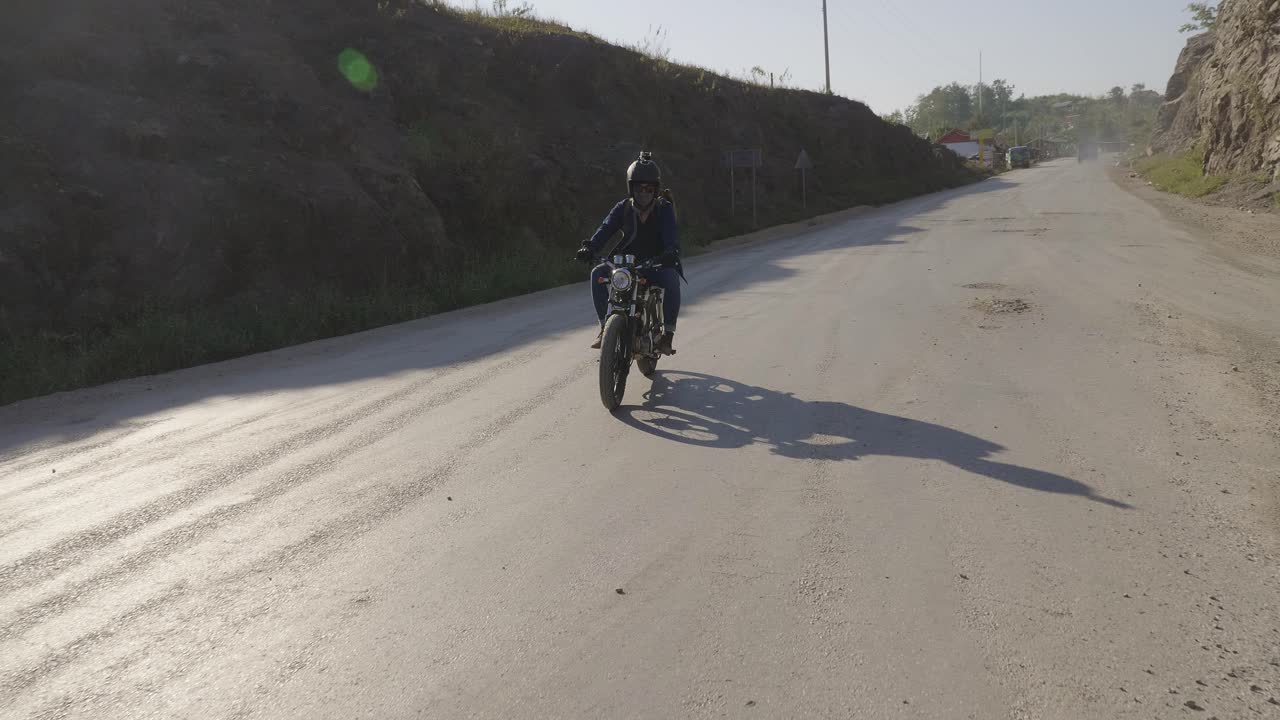 motociclista en un pintoresco camino de montaña
