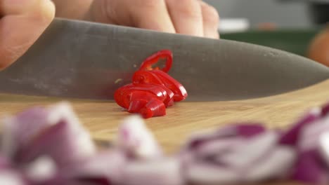 rebanar pimiento rojo en una mesa de madera con un gran cuchillo de chef