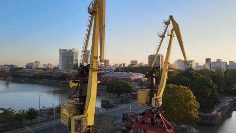 aerial rising shot revealing two old port cranes in puerto madero docks, buenos aires