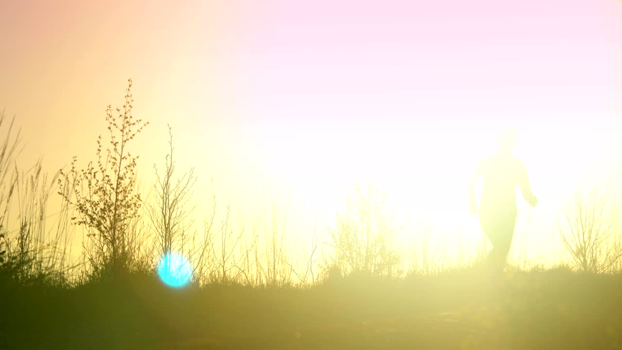 젊은 운동선수 여성은 산의 풍경에서 해가 지는 동안 야외에서 달리고 있습니다.