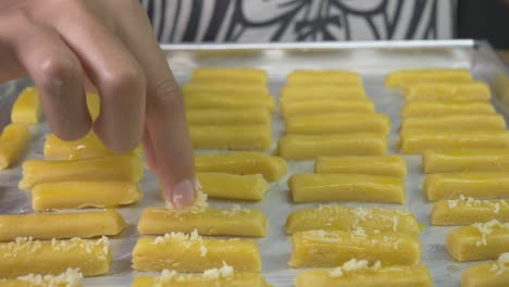 mujer chef añadiendo el queso rallado sobre la masa de galletas lista para hornear