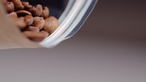 fresh roasted coffee beans falling out of coffee pack in slow motion.static.