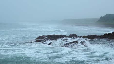 misty ocean coastline with waves and rocks