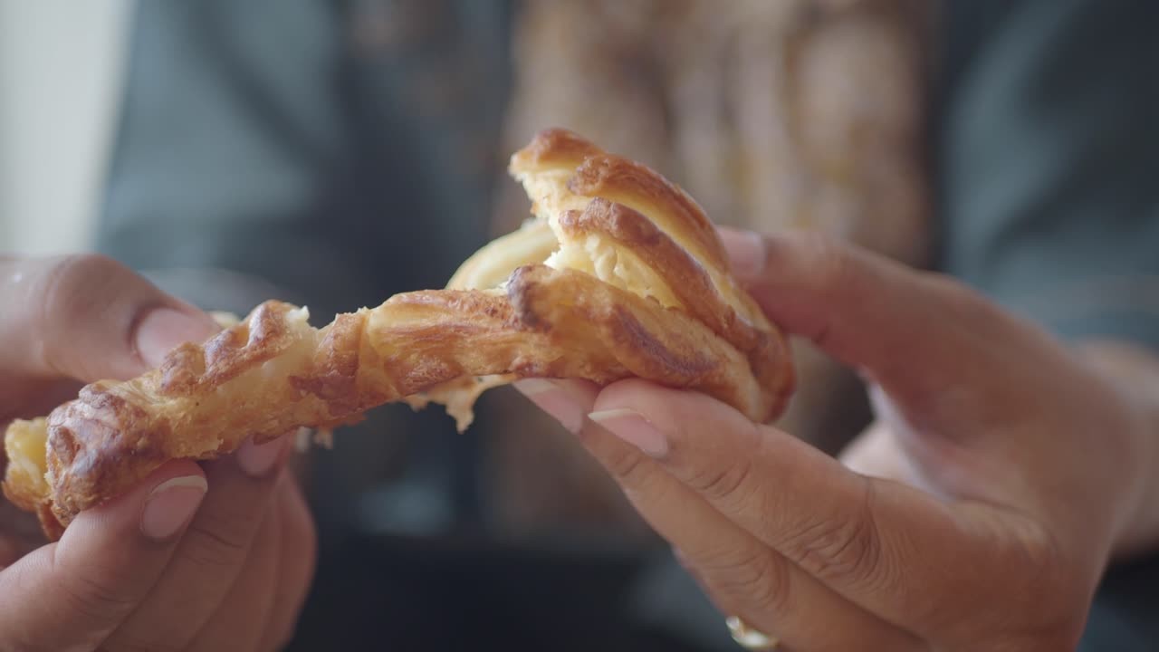 Woman holding a croissant pastry