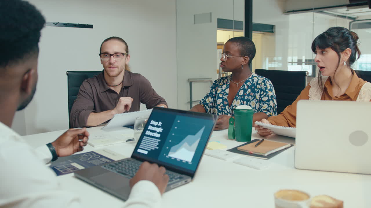 director compartiendo ideas de negocio con diversos empleados en una reunión de oficina