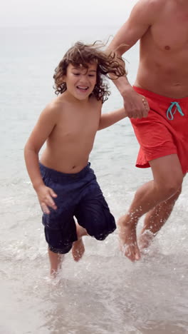 father and children running out of the sea