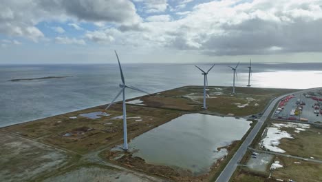 panoramic view: a source of clean energy, four wind turbines in a row, and rotating blades