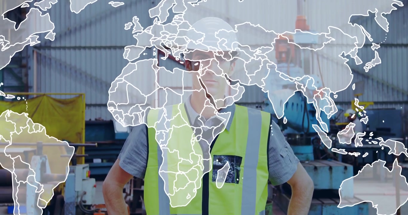 Lavoratore in piedi che indossa un giubbotto ad alta visibilità e un casco bianco in un'officina metallurgica con una sovrapposizione di mappa animata.