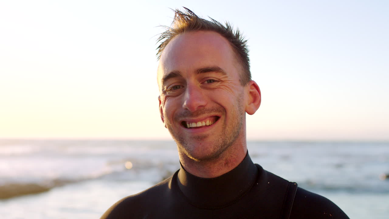 Portrait of a handsome male surfer in a wetsuit by