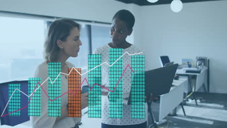 business data charts animation over two businesswomen discussing in modern office