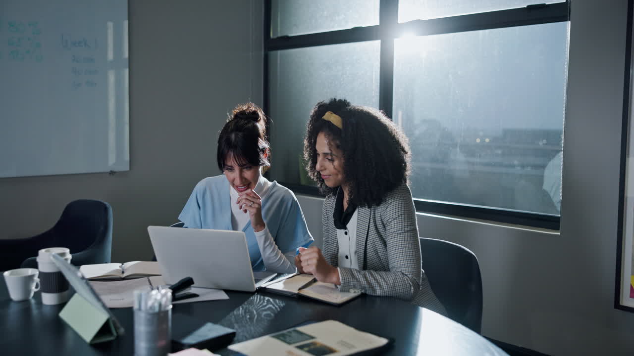 Two Businesswomen Celebrating Success in an Office Meeting