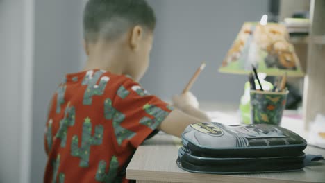 child doing homework at night on his desk