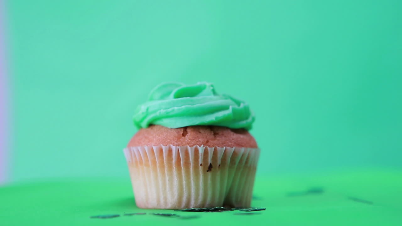 Cupcake di San Patrizio che gira con coriandoli a forma di trifoglio che cadono