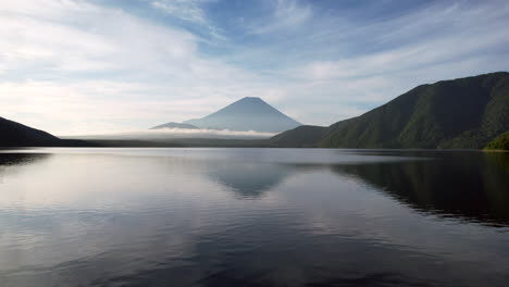 un avión no tripulado capta la belleza reflejada del monte fuji sobre la tranquila extensión del lago motosu.