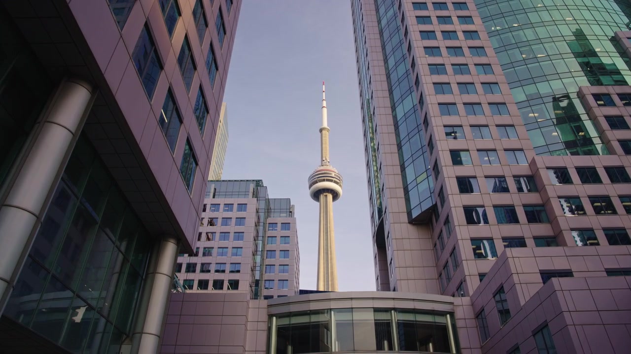 La telecamera si muove in avanti verso la CN Tower, centrata tra gli edifici per uffici del centro, finché non scompare dietro la struttura in primo piano. Hyperlapse.