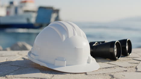 sombrero de ingeniero y binoculares cerca del puerto